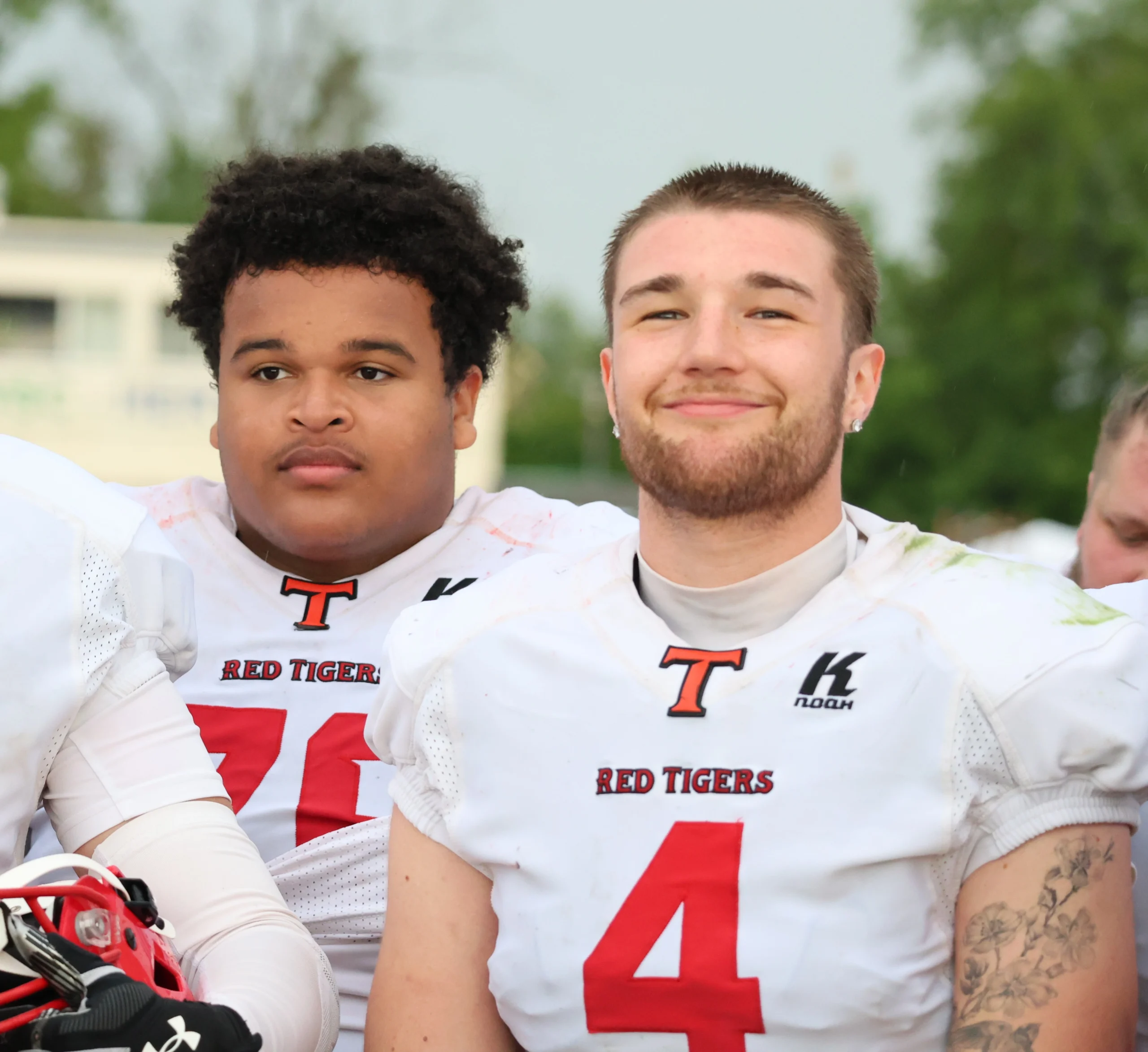 Red Tigers nach dem Spiel – Teamgeist trotz Niederlage Zwei Red Tigers Spieler Nr. 76 und Nr. 4 lächeln nach dem Spiel gegen Huskies Wels entspannt in die Kamera – Teamgeist der Red Tigers 2026